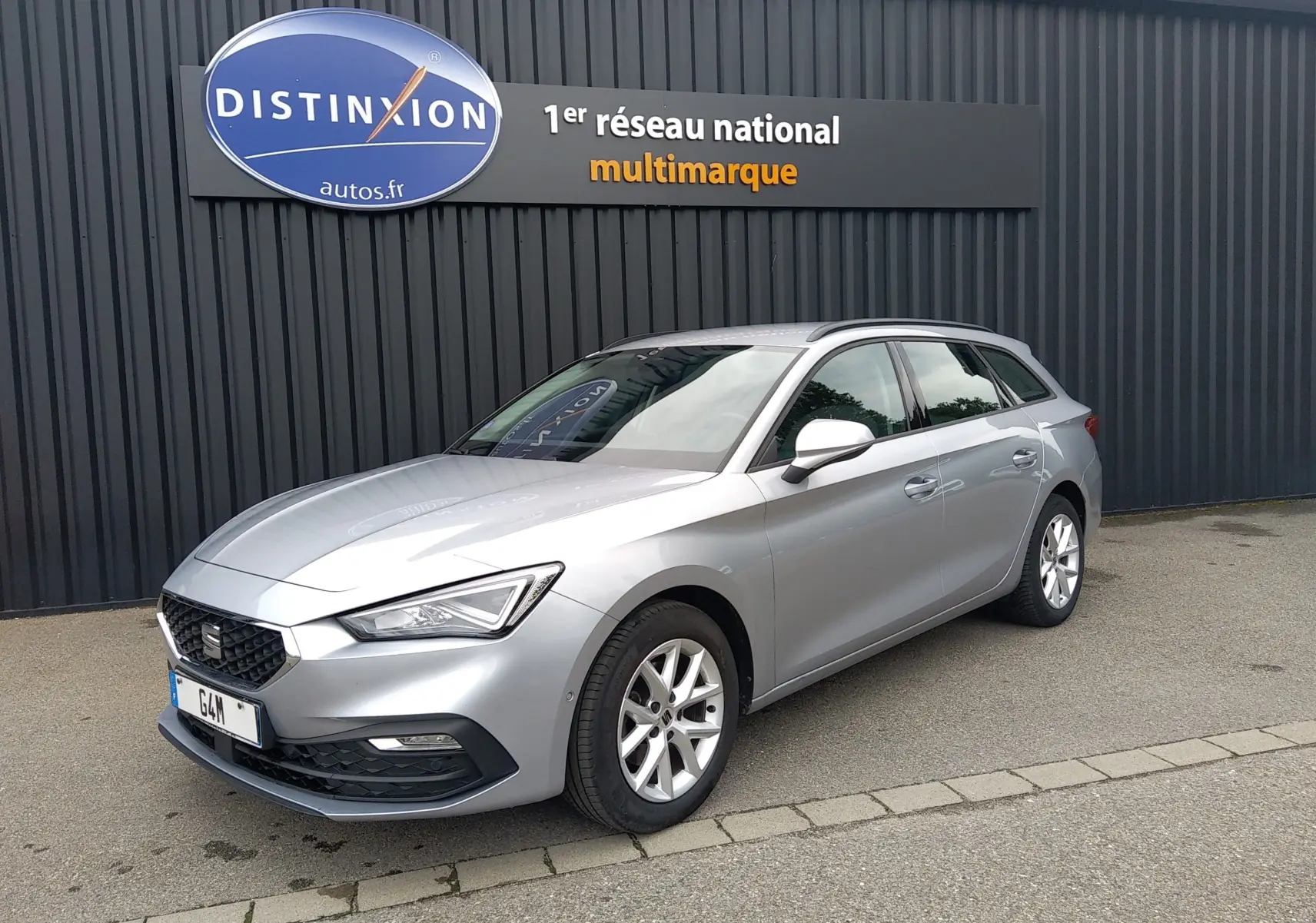 SEAT LEON ST gris en 3/4 avant droit, break compact avec jantes alliage et calandre noire distinctive.