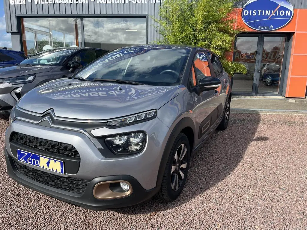 Citroën C3 gris vue 3/4 avant droit, avec projecteurs LED et protections latérales noires.