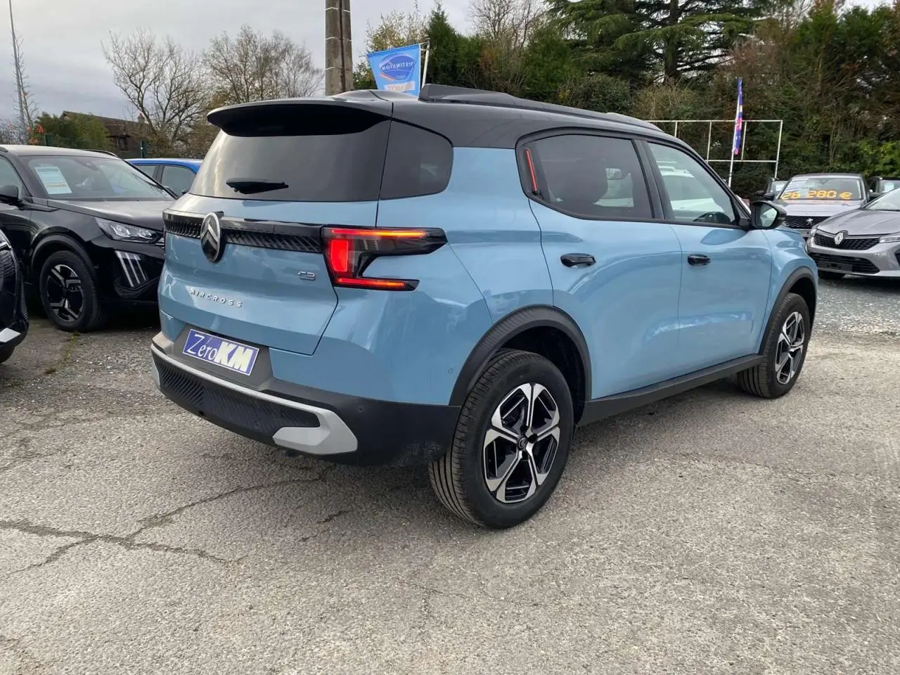 Vue 3/4 arrière droite d'une Citroën C3 Aircross bleu Monte Carlo avec toit noir et feux arrière LED distinctifs.