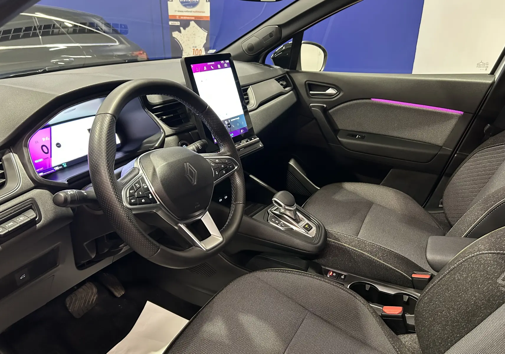 Intérieur de la Renault Symbioz E-Tech Full Hybrid 2025 vu côté conducteur, avec tableau de bord numérique et écran tactile central.