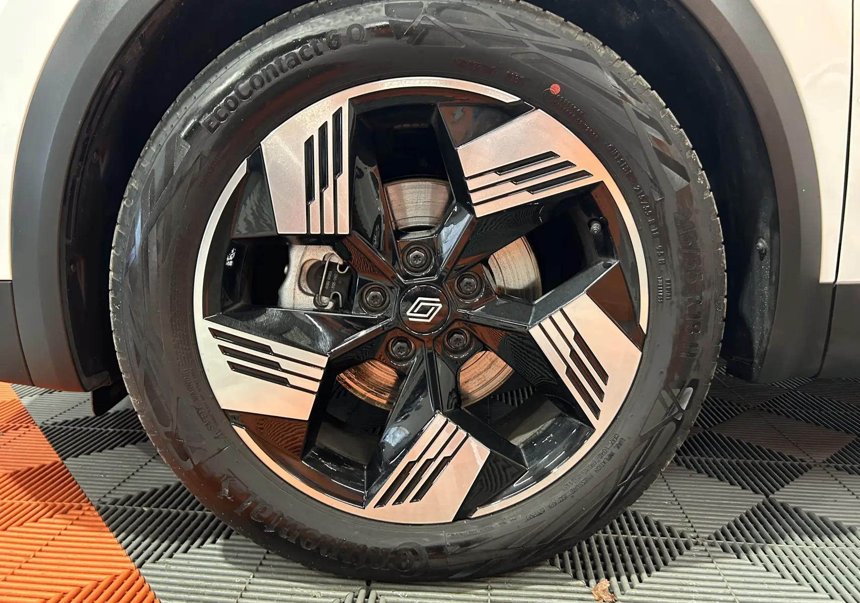 Gros plan sur la roue avant droite du Renault Symbioz blanc nacré avec jante noire et argentée au design géométrique.