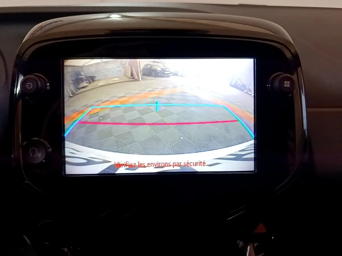 Écran tactile central montrant la caméra de recul d'une Citroën C1 gris clair, vue intérieure du tableau de bord.