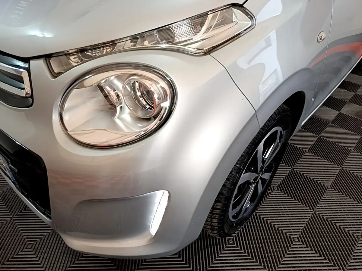 Gros plan sur l'avant droit gris clair de la Citroën C1 2019, mettant en valeur le phare rond et la roue noire.