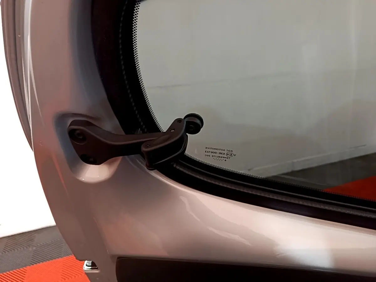 Gros plan sur la charnière de la porte arrière droite d'une Citroën C1 gris clair 2019, finition Shine.