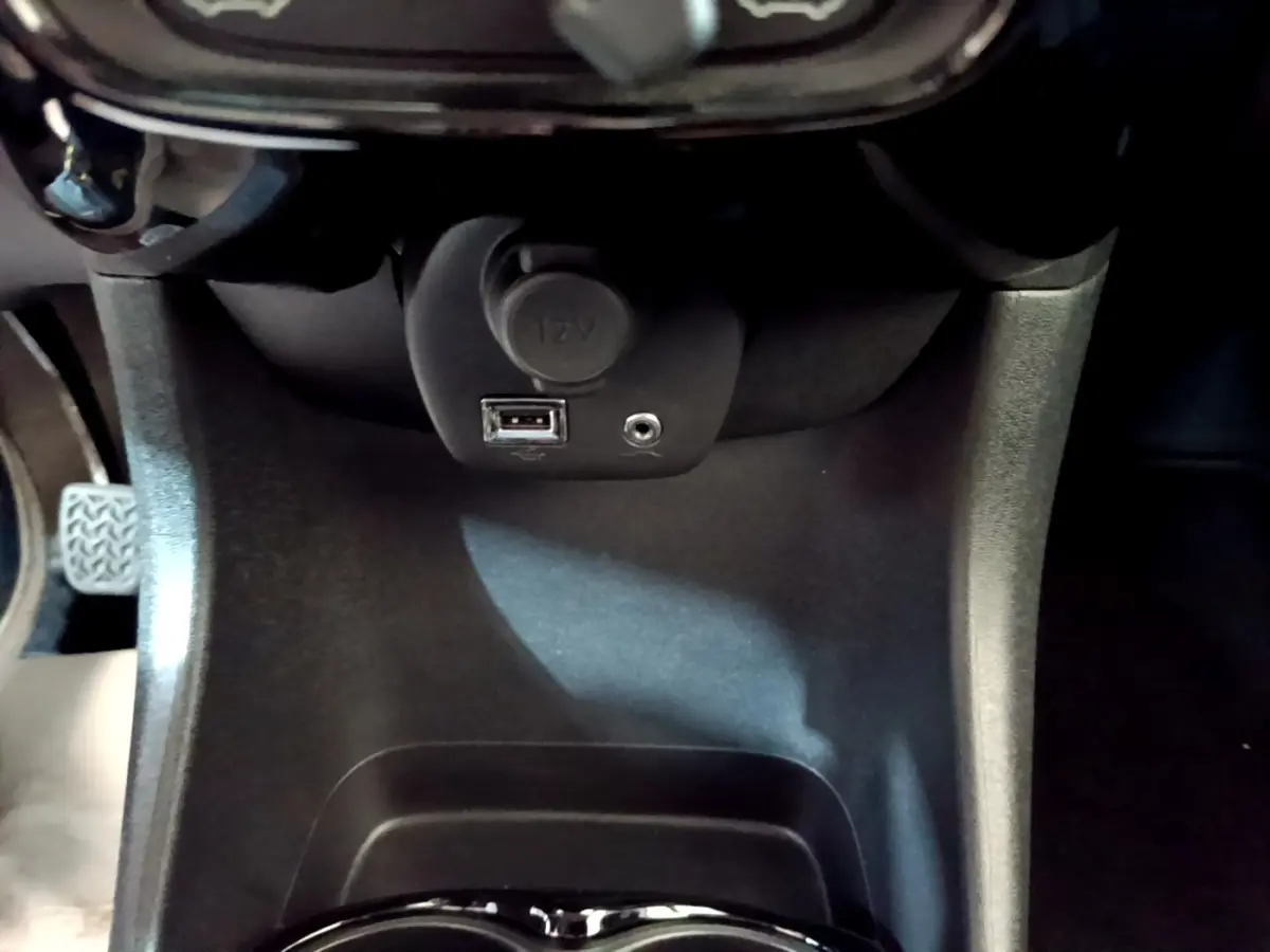 Vue rapprochée de la prise 12V et port USB dans l’habitacle noir du Citroën C1 gris clair, version Shine 2019.