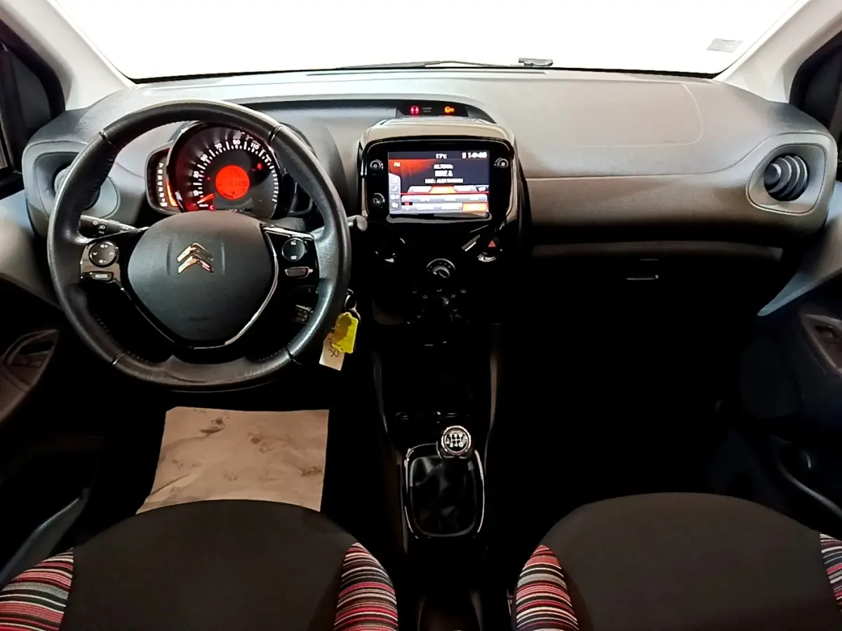 Intérieur de Citroën C1 2019 vue de face, tableau de bord noir avec écran tactile et volant cuir multifonctions.