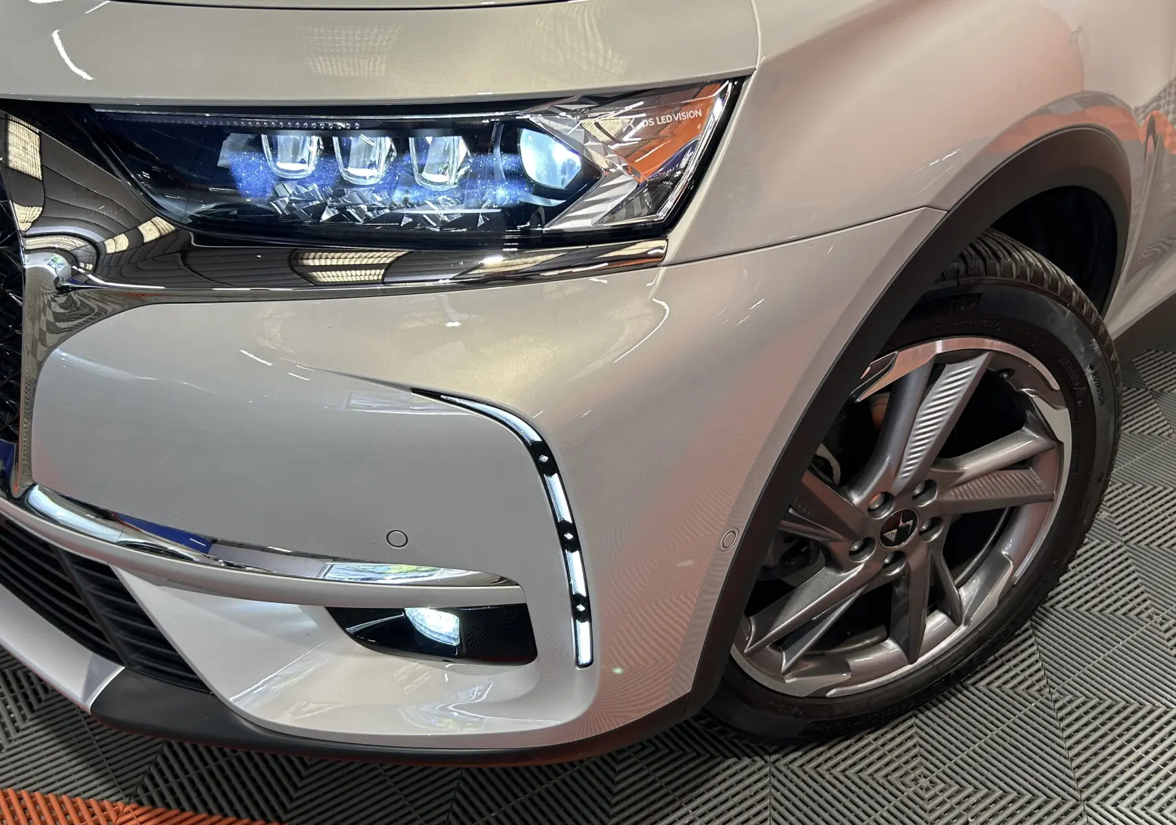 Gros plan sur l’avant droit du DS7 Crossback Cristal Pearl, mettant en valeur le phare LED et la jante alliage.