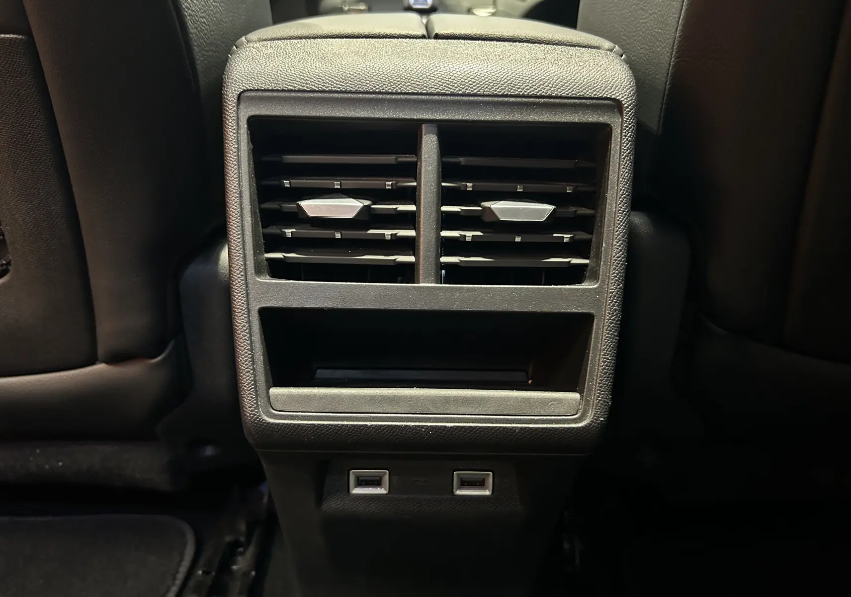 Vue rapprochée des aérateurs arrière et ports USB noirs du DS7 Crossback 2022 dans un intérieur sombre.
