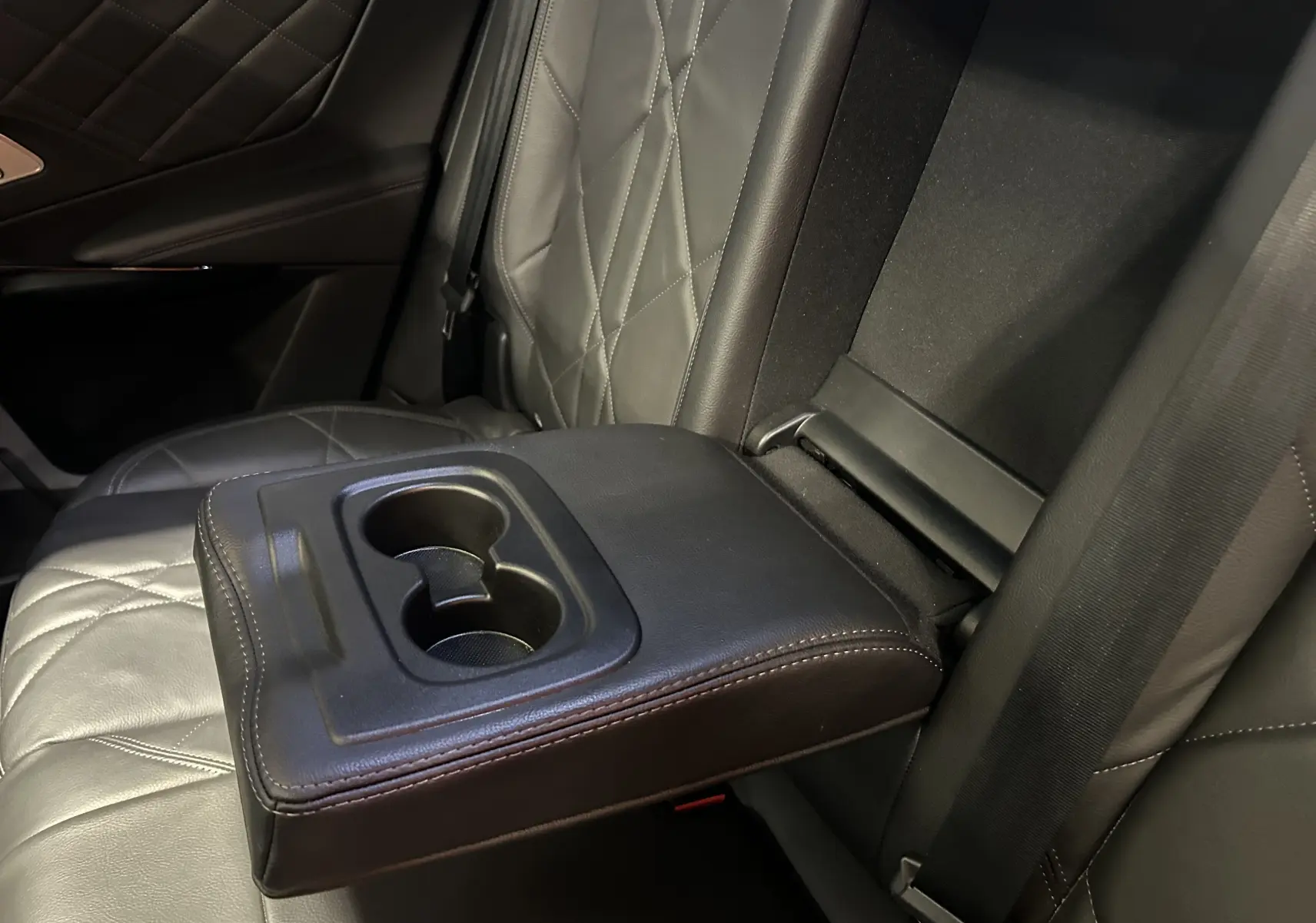 Gros plan sur l'accoudoir central arrière en cuir noir avec porte-gobelets du DS7 Crossback 2022.