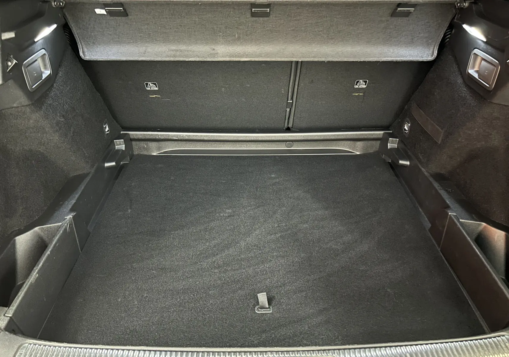 Vue intérieure du coffre spacieux et propre du DS7 Crossback 2022, revêtement noir et finitions soignées.