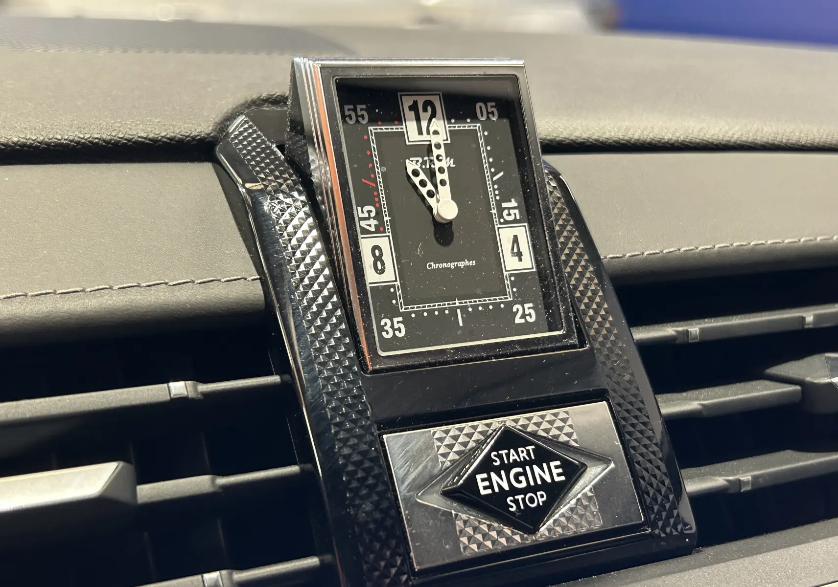 Gros plan sur l'horloge analogique et le bouton Start Engine Stop du tableau de bord noir du DS7 Crossback 2022.