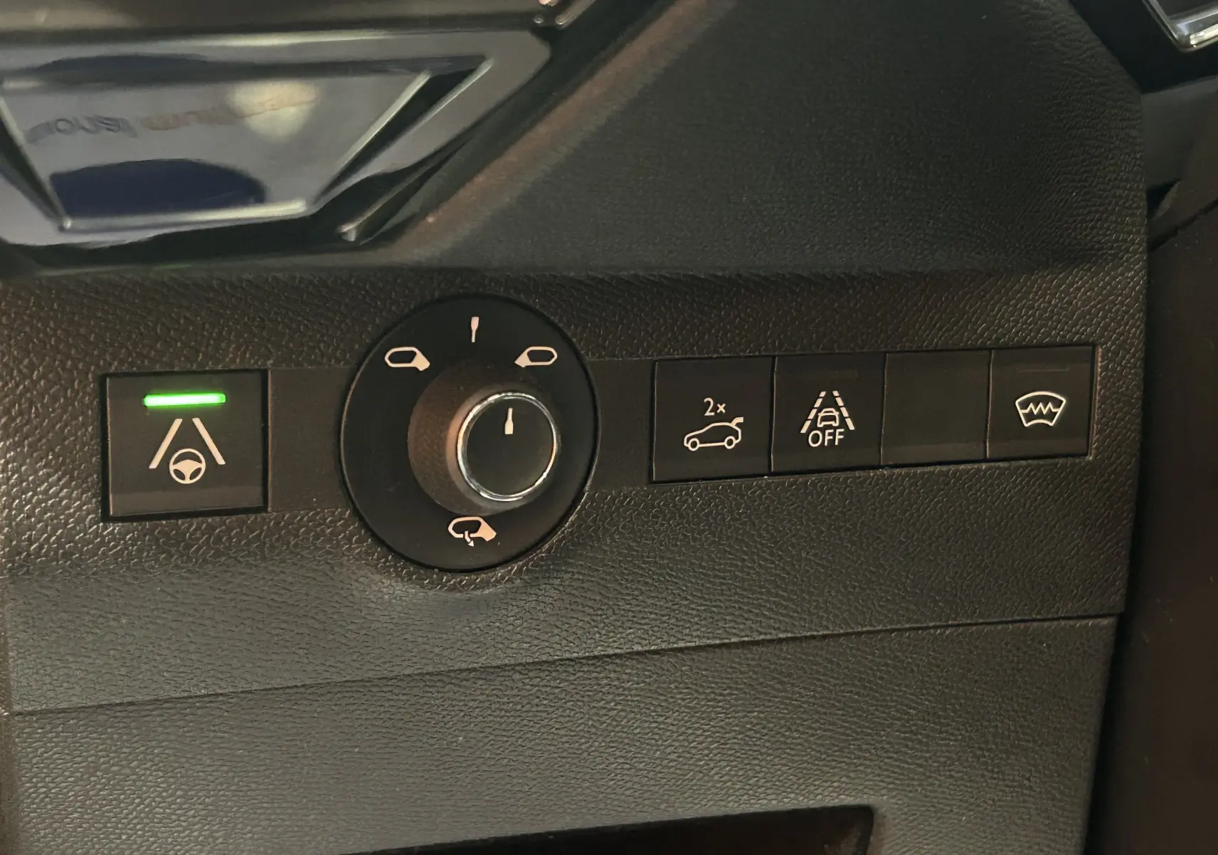 Gros plan sur les commandes intérieures noires du DS7 Crossback 2022, avec témoin vert allumé sur l'assistance au maintien de voie.