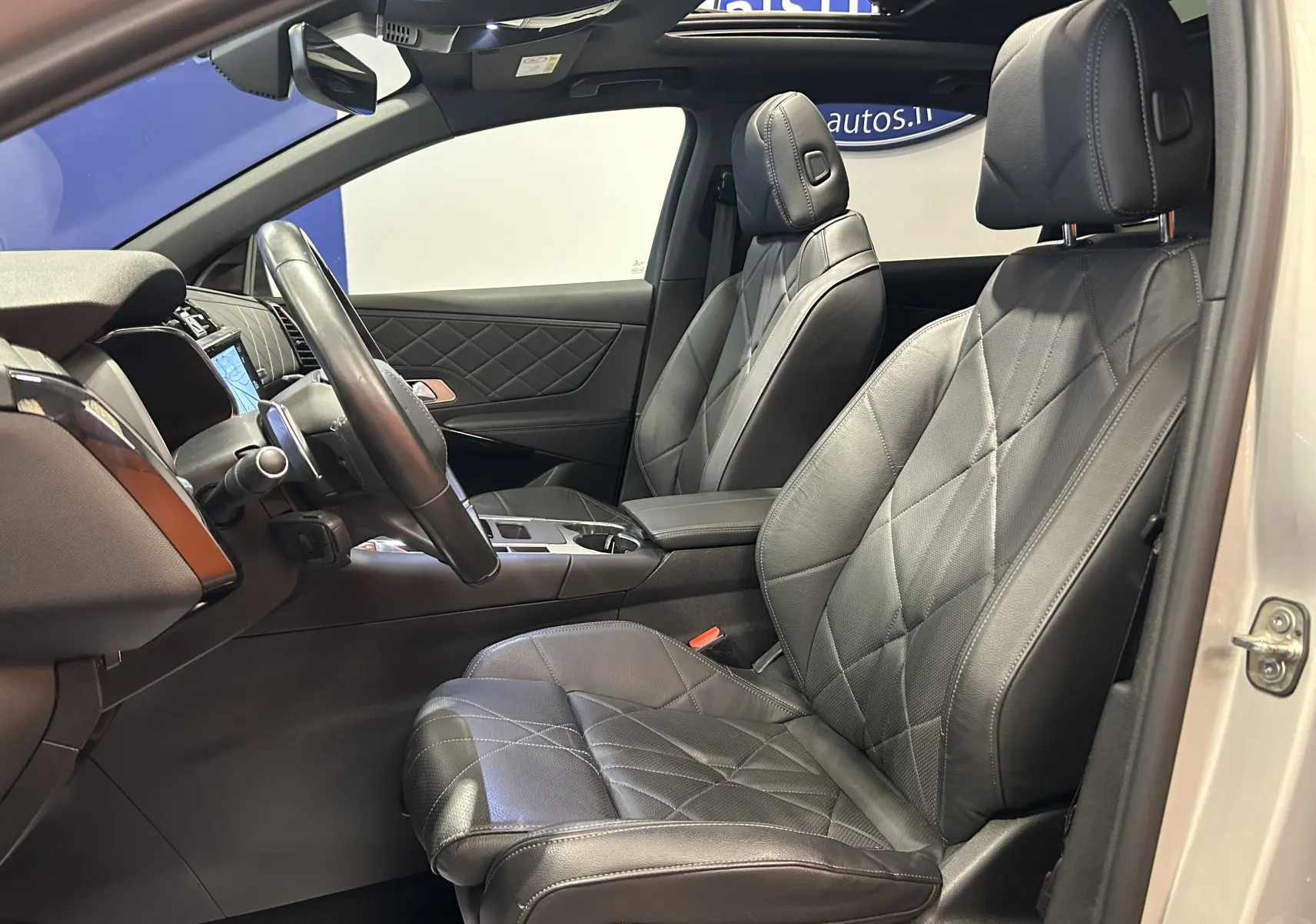 Vue intérieure côté conducteur du DS7 Crossback 2022, sièges cuir noir matelassé et tableau de bord élégant.