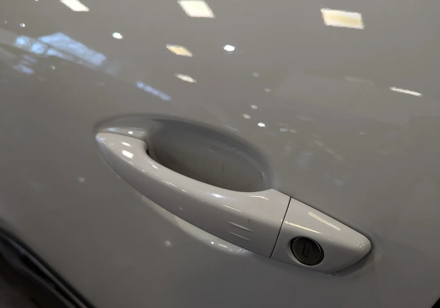 Poignée de porte blanche du côté gauche d'un Peugeot 3008 Crossway 2018 avec serrure visible.