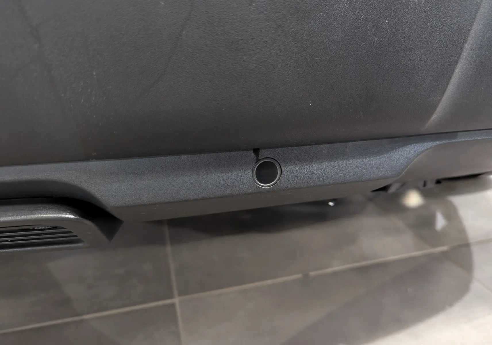 Gros plan sur un capteur de stationnement noir intégré au pare-chocs arrière du Peugeot 3008 blanc Glacier toit noir.