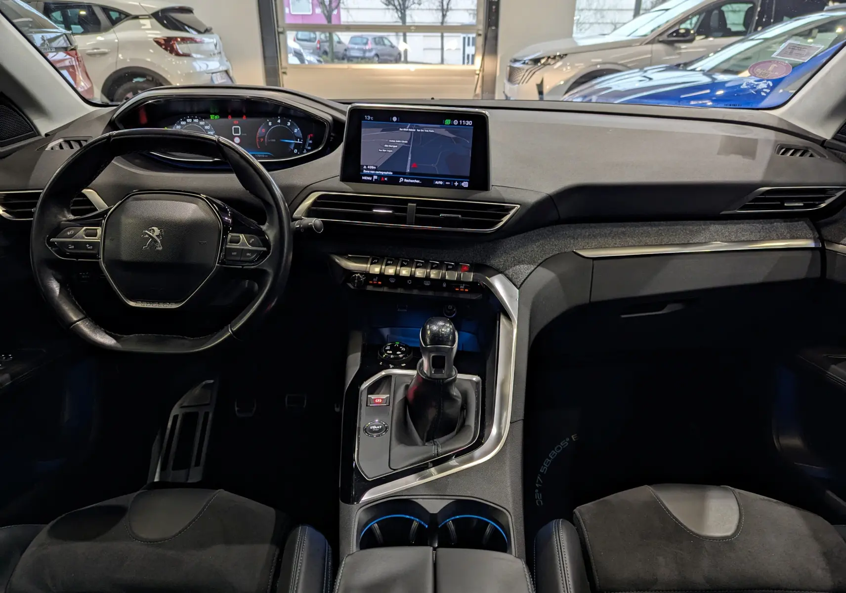 Vue intérieure frontale du tableau de bord et volant du Peugeot 3008 1.2 PureTech 2018 avec écran tactile et levier de vitesses manuel.