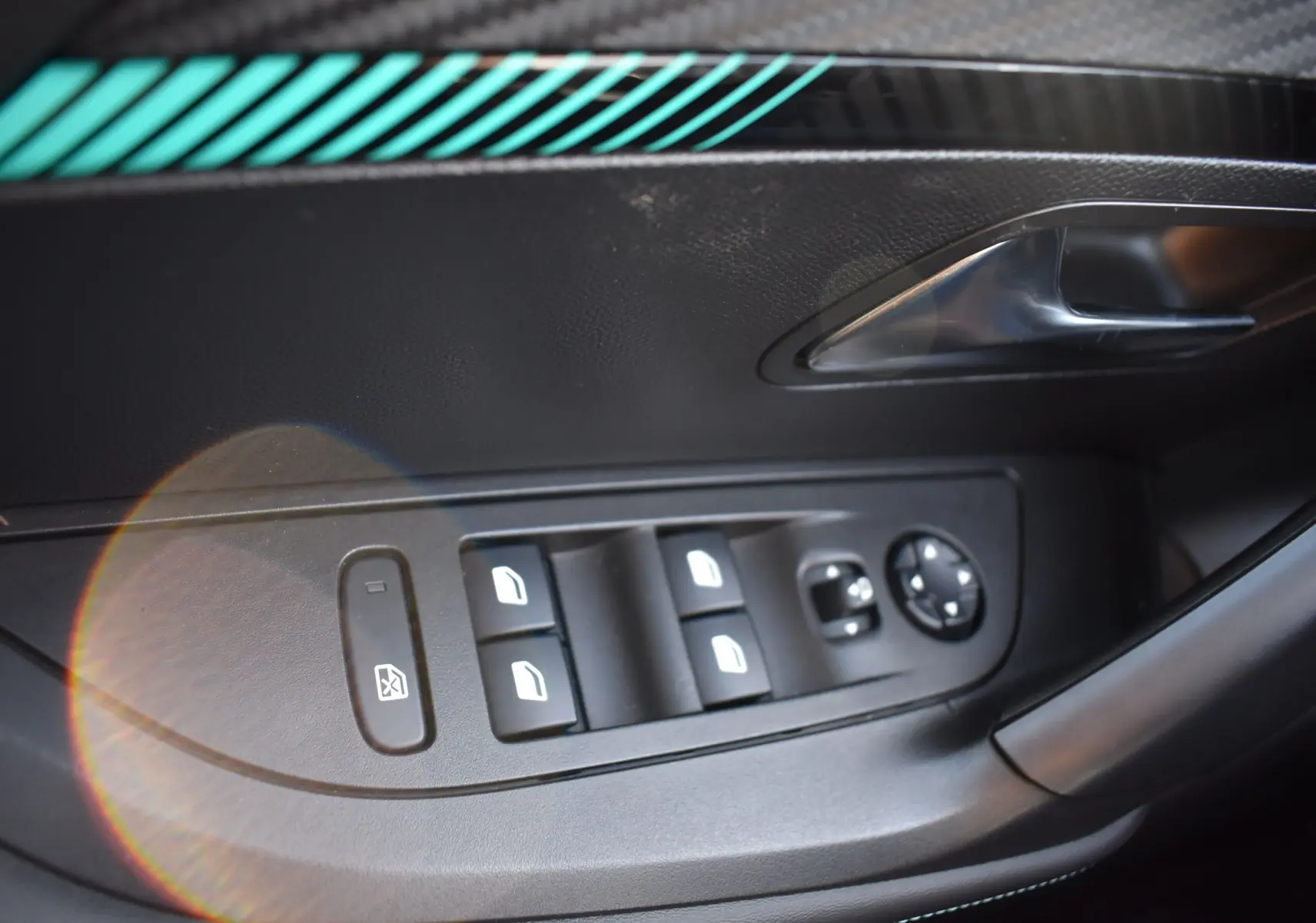 Commande des vitres électriques et réglage des rétroviseurs sur la porte côté gauche d'un Peugeot 2008 bleu 2021 finition Allure.