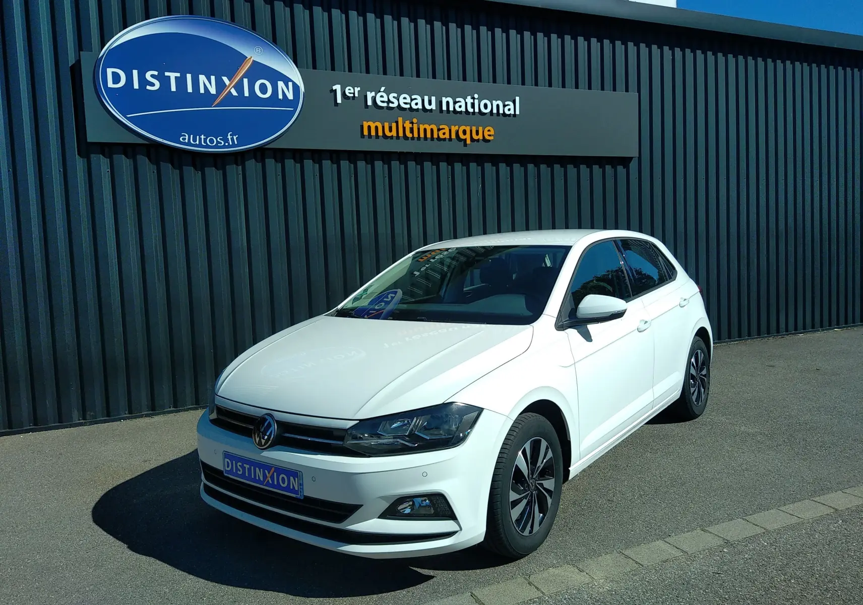 Volkswagen Polo 1.0 TSI blanche vue en 3/4 avant droit, avec jantes alliage et calandre noire brillante.