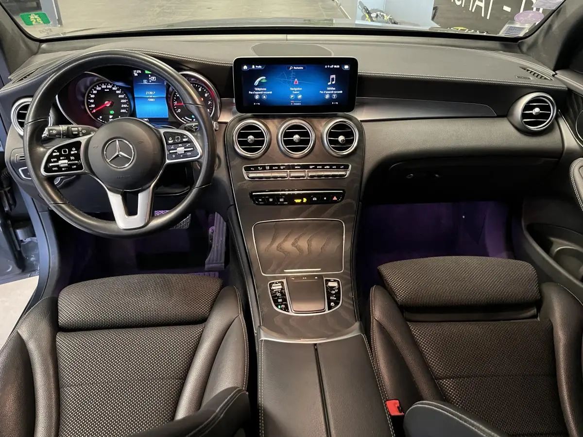 Vue intérieure du tableau de bord et console centrale du Mercedes GLC 2019 avec volant cuir noir et écran tactile.