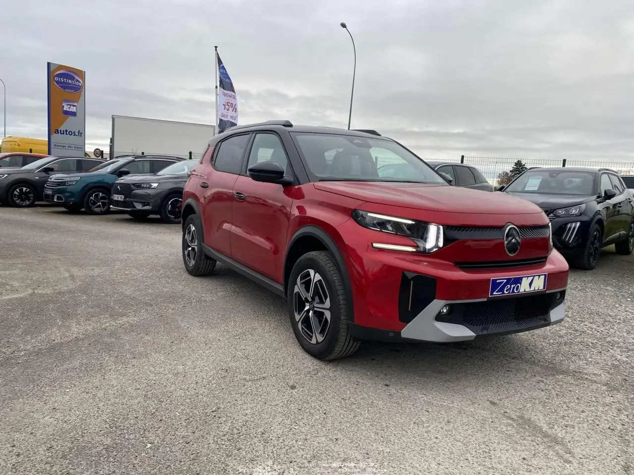 SUV Citroën C3 Aircross rouge Elixir avec toit noir, vu en 3/4 avant droit sur parking extérieur.