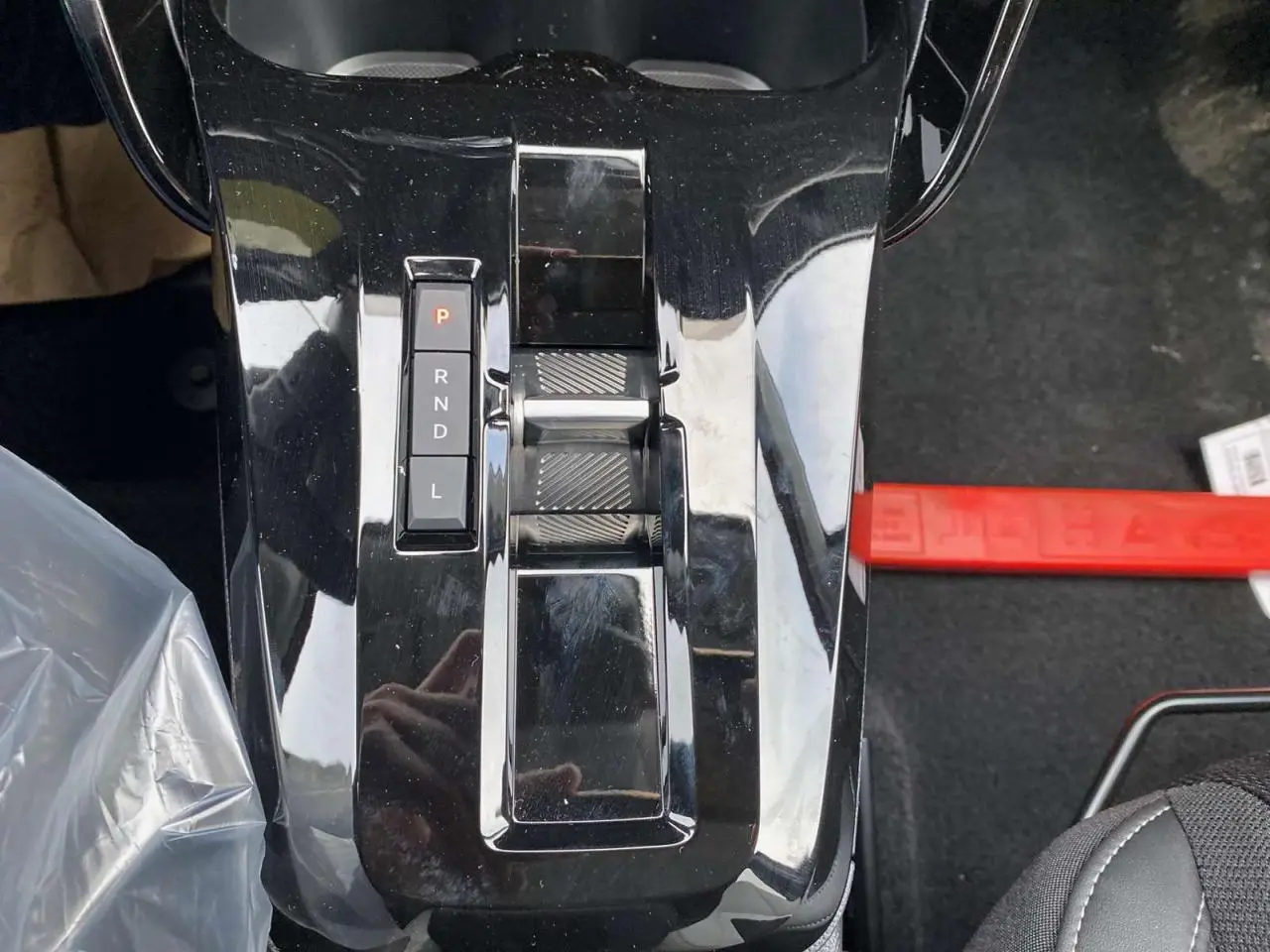 Gros plan sur la console centrale noire brillante avec levier de vitesses automatique de la Citroën C3 Aircross hybride.