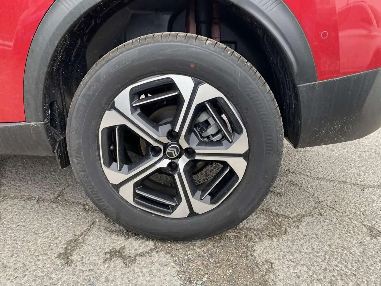 Gros plan sur la roue avant gauche du Citroën C3 Aircross rouge Elixir avec jante alliage 17'' Aragonite diamantée.