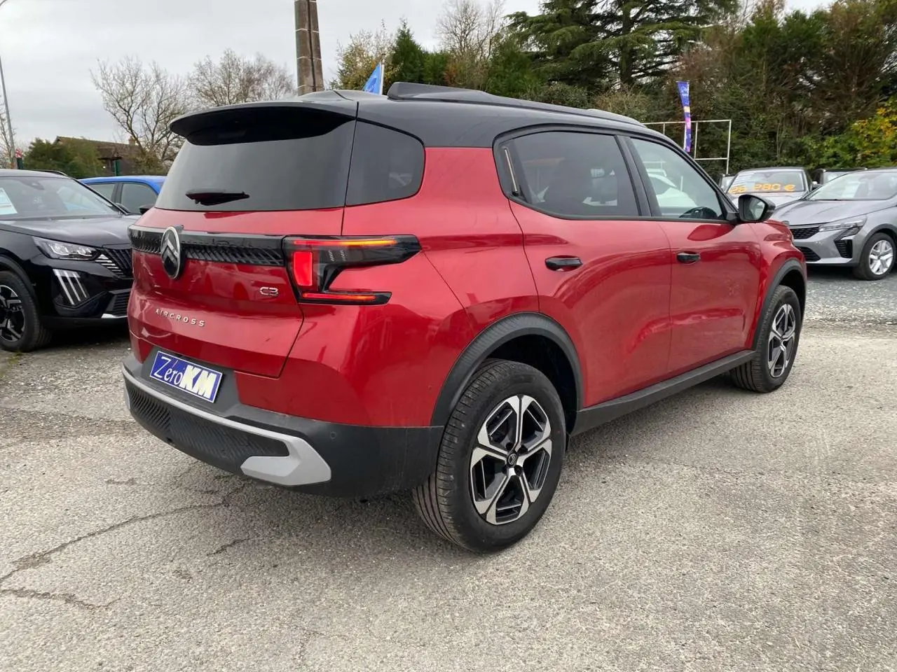 Vue 3/4 arrière droite d'un Citroën C3 Aircross 2025 rouge Elixir avec toit noir et feux arrière LED 3D.