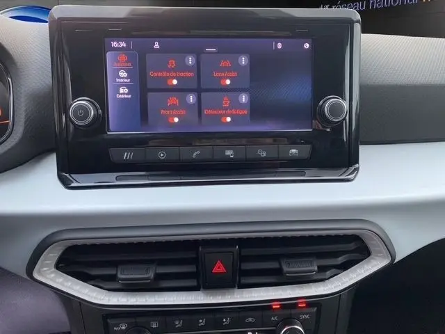 Écran tactile central de la SEAT Ibiza blanche 2023 affichant les aides à la conduite, vue de face rapprochée.