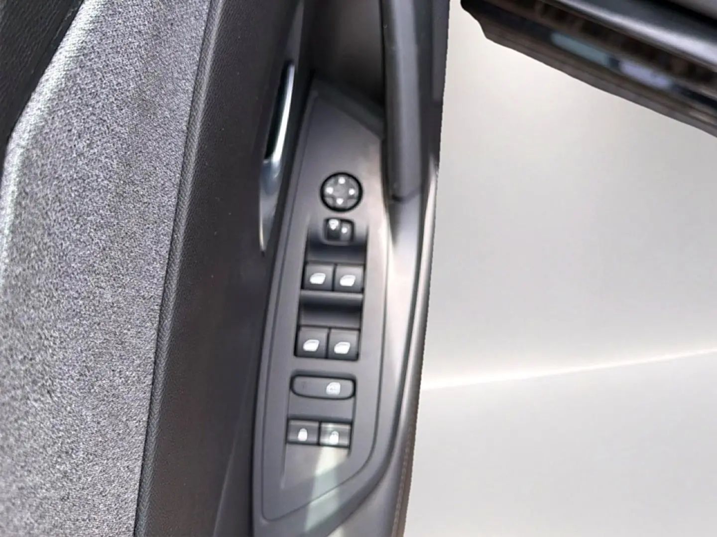 Vue rapprochée des commandes des vitres et rétroviseurs sur la porte côté gauche d’une Peugeot 408 noire.