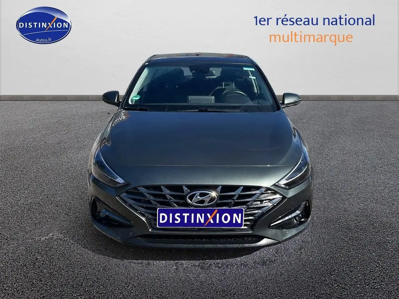 Vue frontale d'une Hyundai i30 gris argent 2024 avec calandre chromée et phares LED distinctifs.