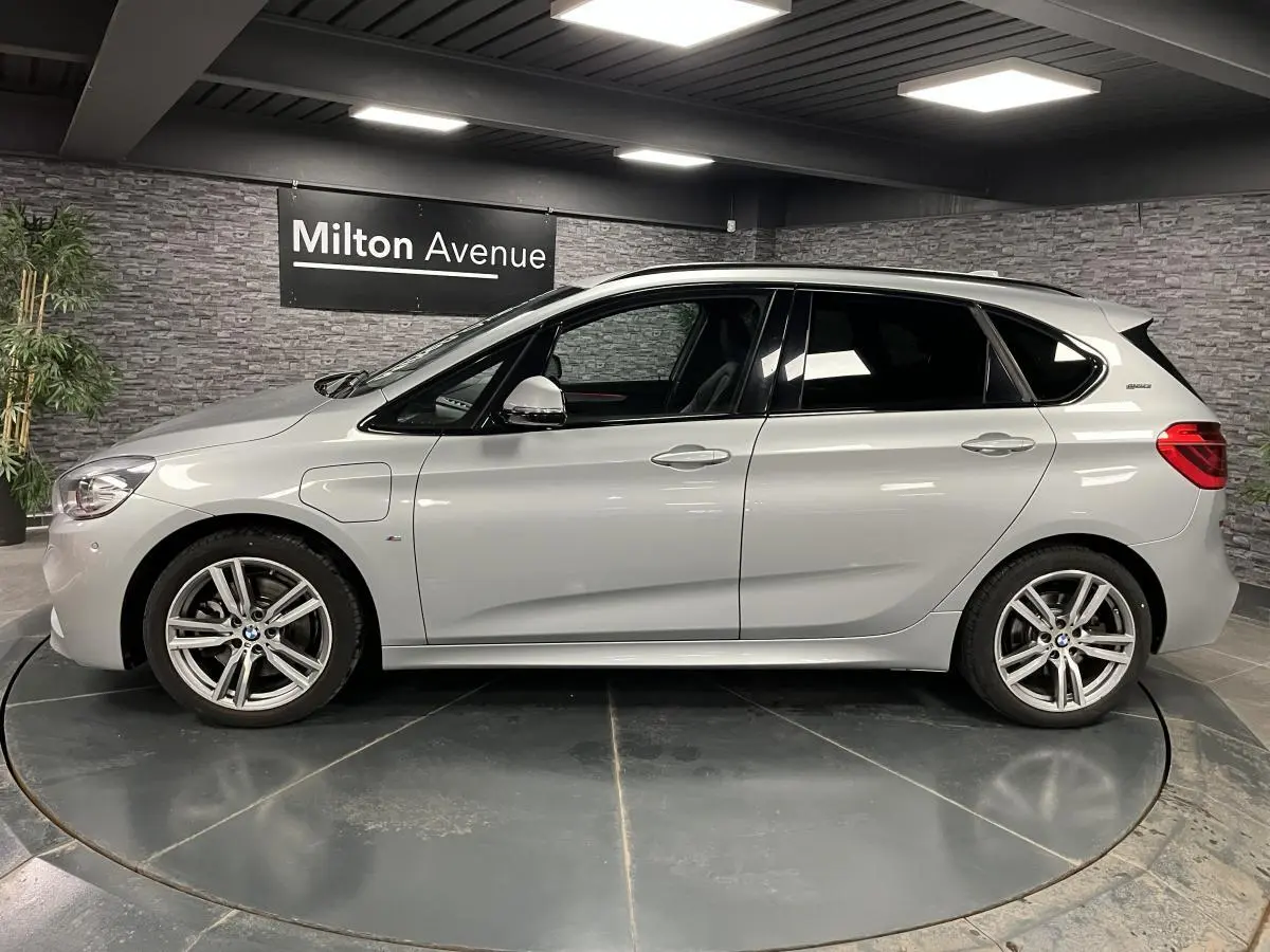 BMW Série 2 225xe Active Tourer hybride gris vue de profil côté gauche en intérieur showroom
