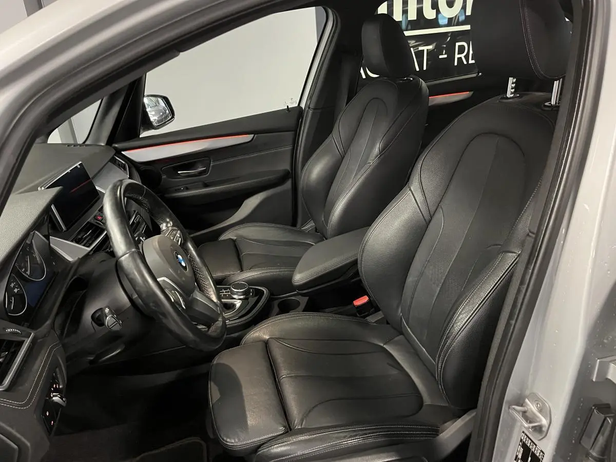 Intérieur noir cuir de la BMW Série 2 225xe Active Tourer 2018, vue côté conducteur avec tableau de bord et sièges avant.