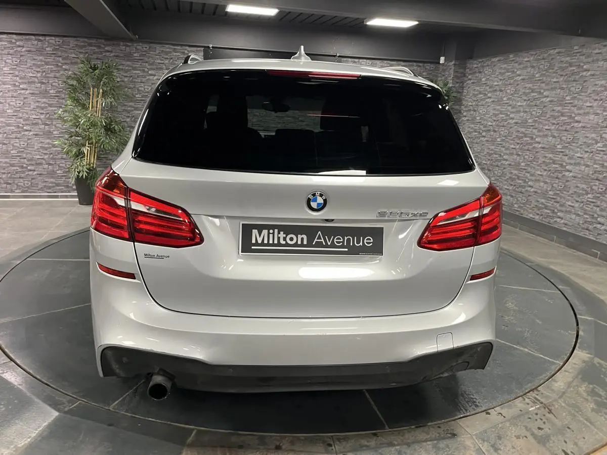 Vue arrière d'une BMW Série 2 225xe Active Tourer gris métallisé avec logo et feux rouges allongés.