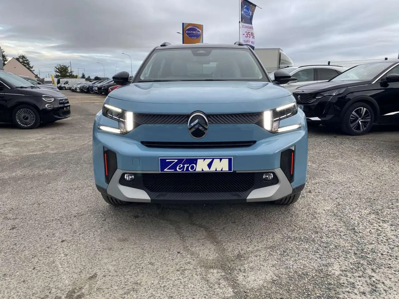 Vue frontale d'un Citroën C3 Aircross hybride bleu Monte Carlo avec toit noir et feux LED allumés.