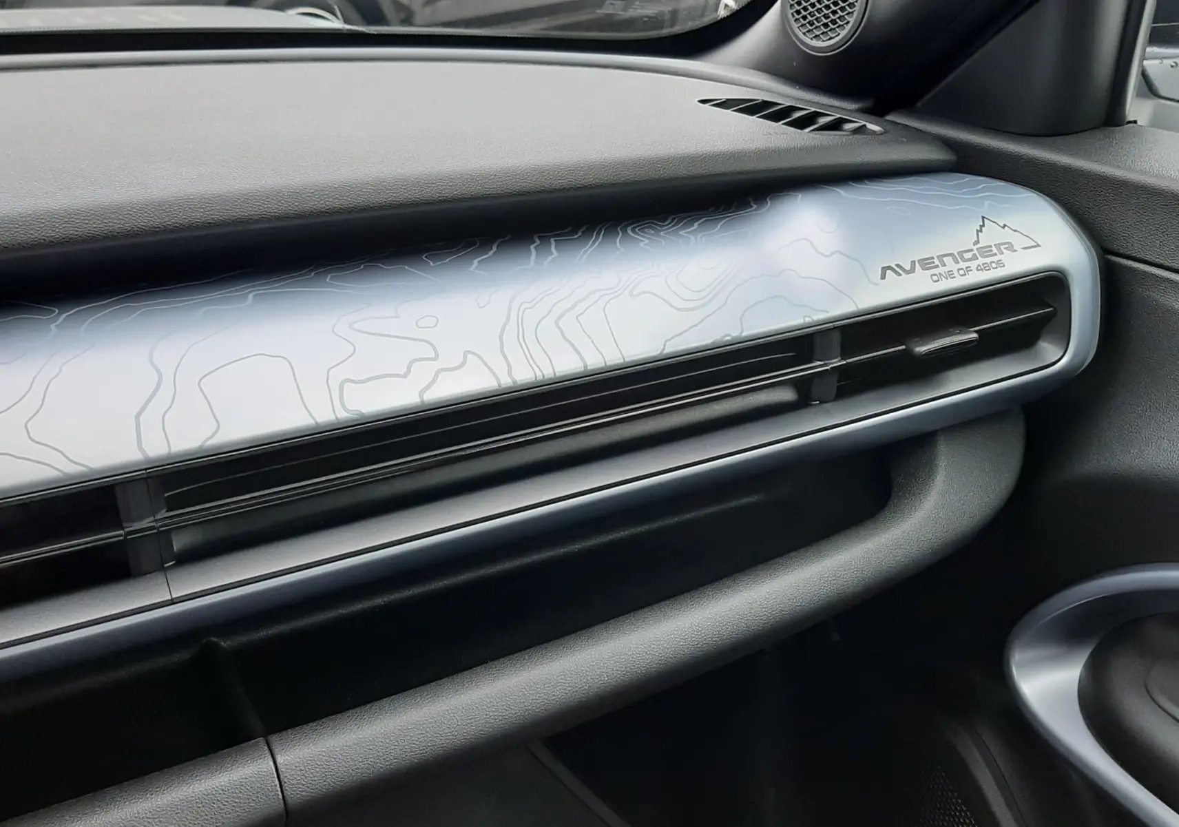 Vue intérieure côté passager du tableau de bord du Jeep Avenger 2025 avec habillage gris clair et logo Avenger One of 6205.