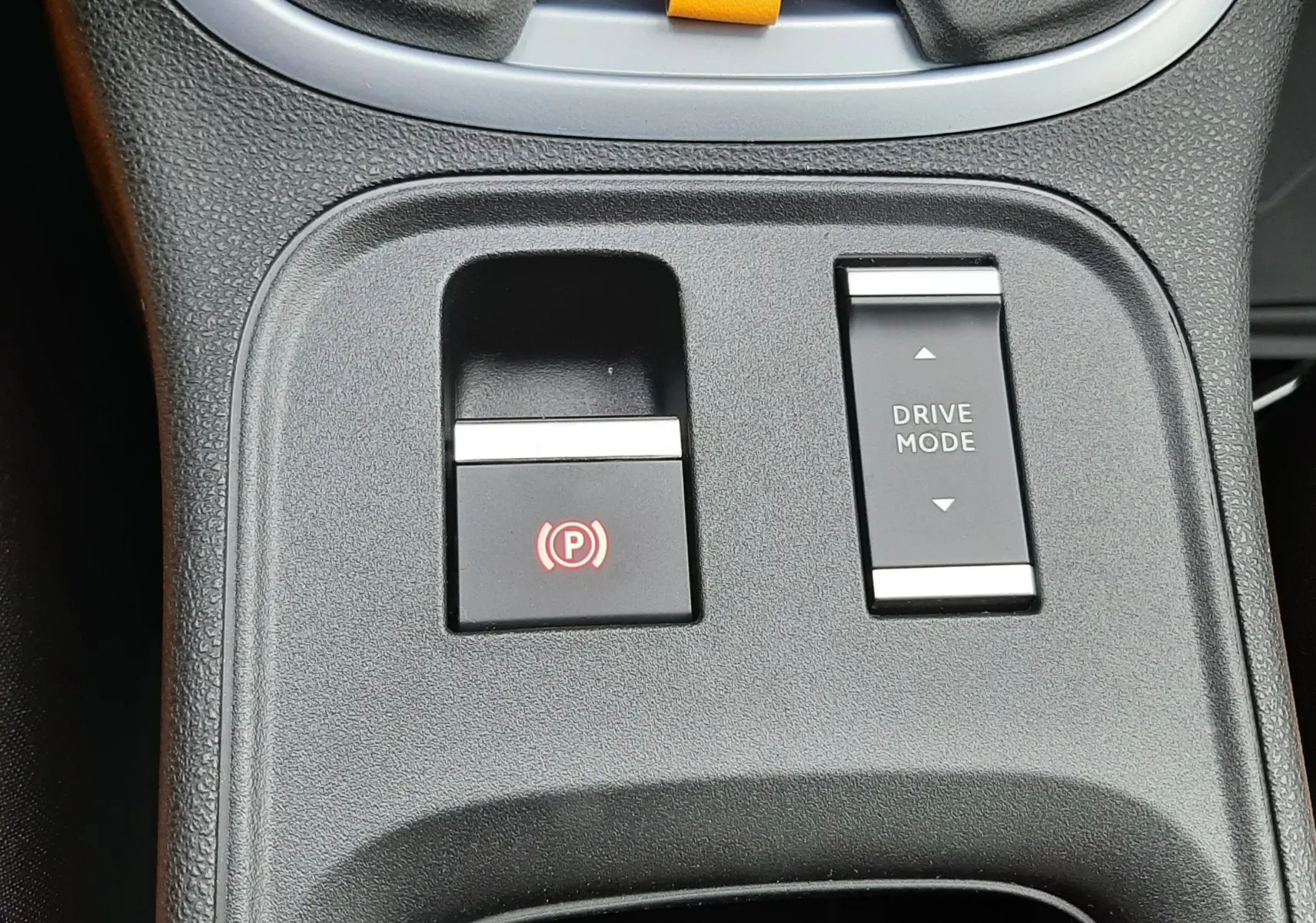 Gros plan sur la console centrale du Jeep Avenger 2025, boutons frein électrique et mode de conduite visibles.