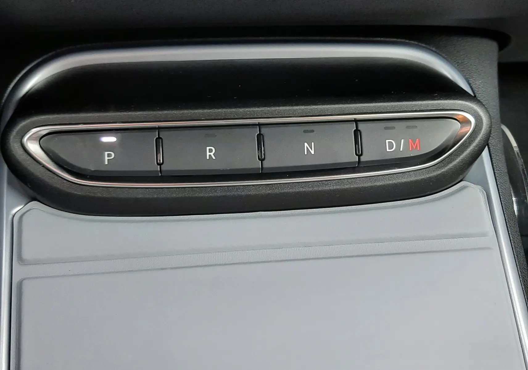 Gros plan sur la commande de boîte automatique du Jeep Avenger, boutons P, R, N, D/M avec éclairage blanc et rouge.