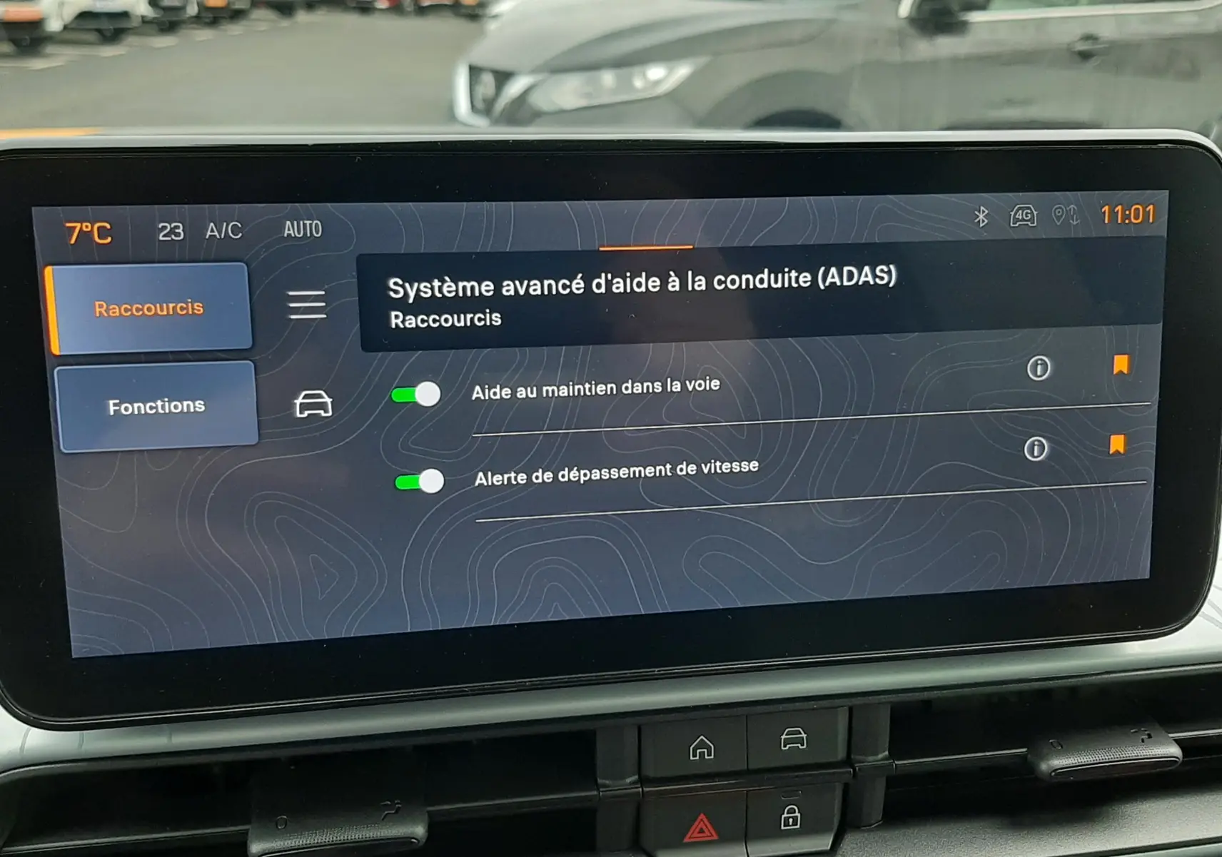 Écran tactile intérieur du Jeep Avenger 2025 affichant les aides à la conduite, avec vue floue du parking à l'arrière.