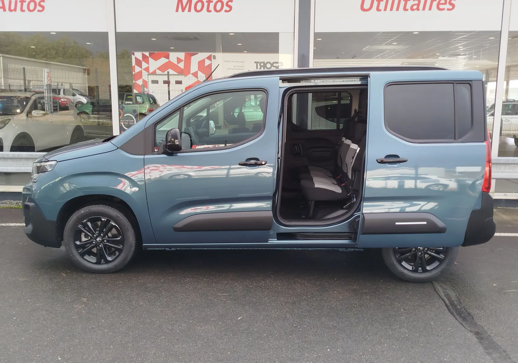 Vue latérale droite du Citroën Berlingo bleu Kiarma 2025 avec porte coulissante ouverte et intérieur visible.