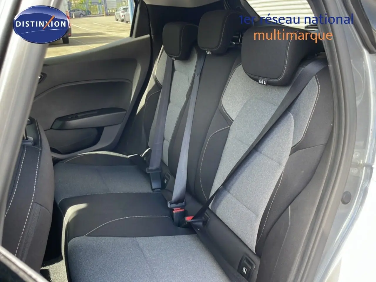 Vue intérieure sur les sièges arrière en tissu bicolore gris et noir de la Renault Clio 2025, porte arrière ouverte côté droit.