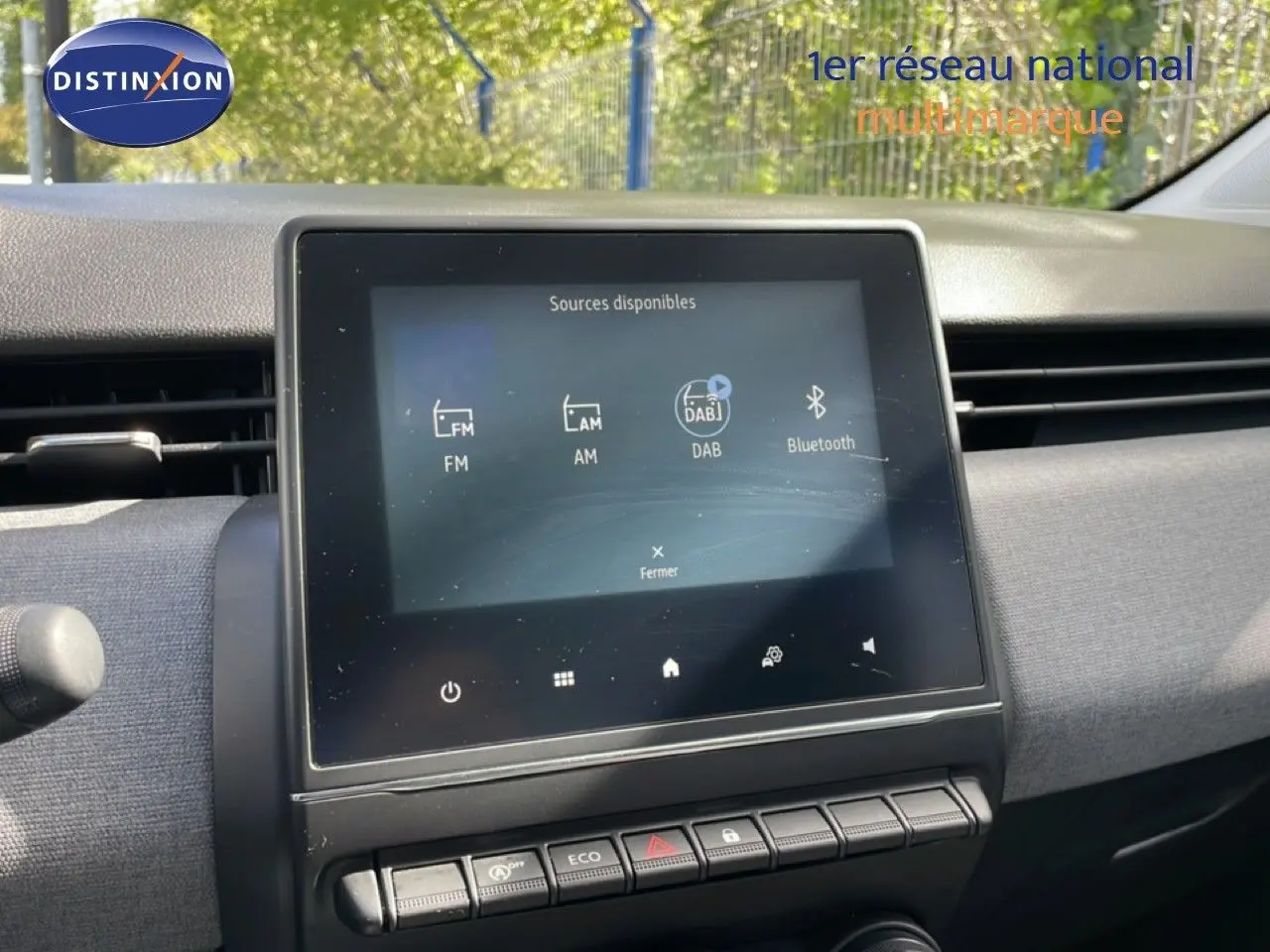 Vue intérieure centrée sur l'écran tactile multimédia de la Renault Clio gris schiste 2025, avec commandes en dessous.