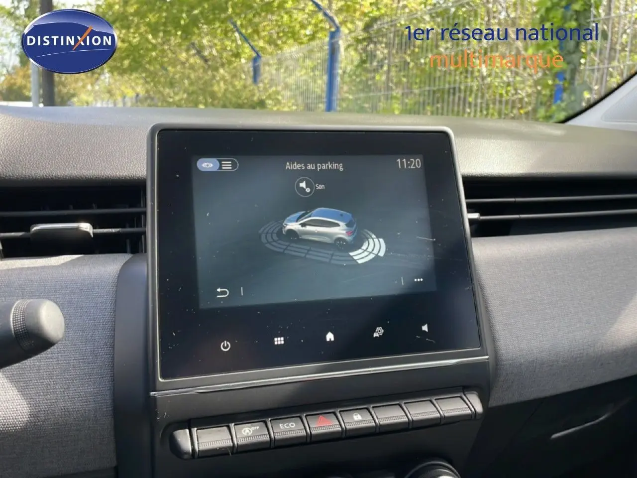 Vue intérieure centrée sur l’écran tactile du tableau de bord de la Renault Clio gris schiste, affichant l’aide au parking.