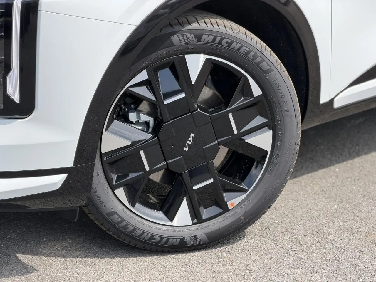 Gros plan sur la roue avant droite du KIA SPORTAGE blanc avec jante alliage noire et argentée, pneus Michelin.