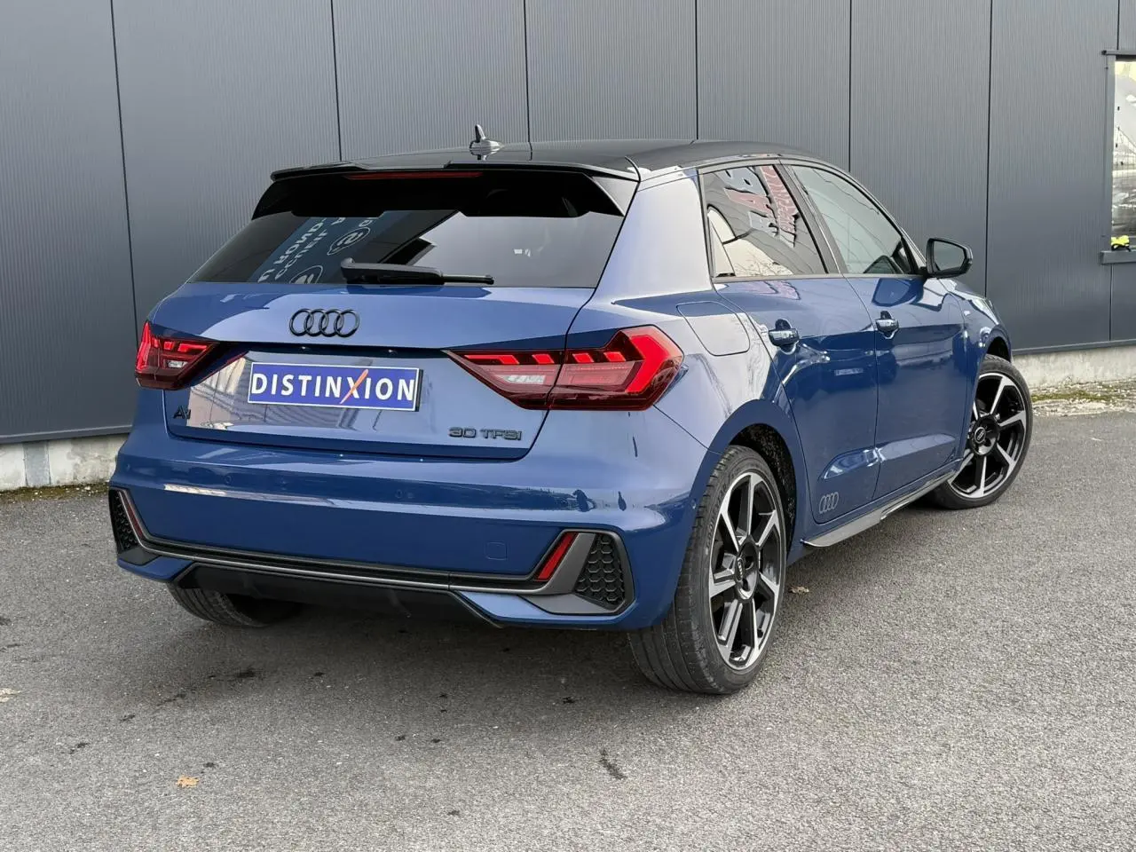 Audi A1 Sportback 30 TFSI bleu Ascari en 3/4 arrière droit, avec toit noir et jantes Rotor noires anthracite.