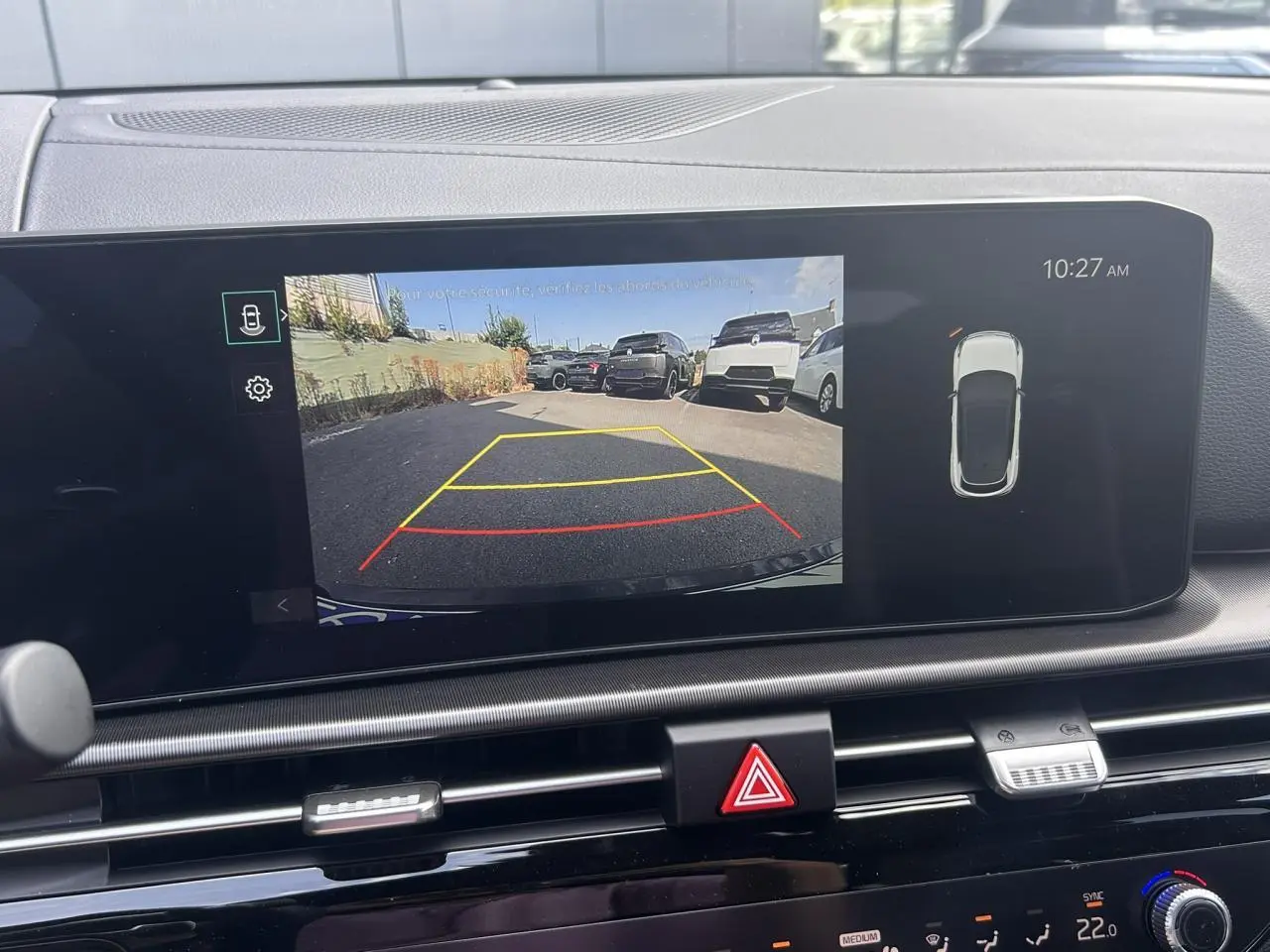 Écran tactile intérieur du Kia Sportage noir 2026 montrant la caméra de recul avec lignes de guidage colorées.