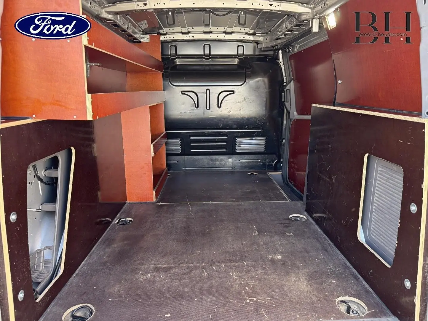 Vue intérieure arrière du Ford Transit Connect L2 2022 avec aménagements en bois et plancher noir.