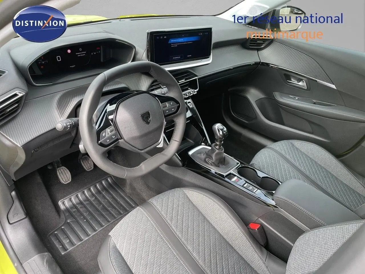 Intérieur moderne de Peugeot 208 2025, vue côté conducteur, volant compact et console centrale avec boîte manuelle.