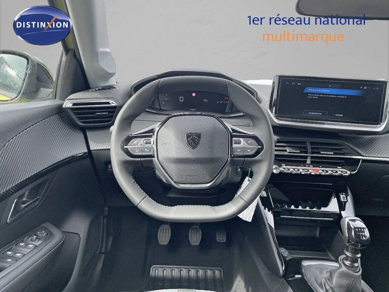 Vue intérieure centrée sur le poste de conduite d'une Peugeot 208 1.2 PureTech avec volant multifonction et boîte manuelle.