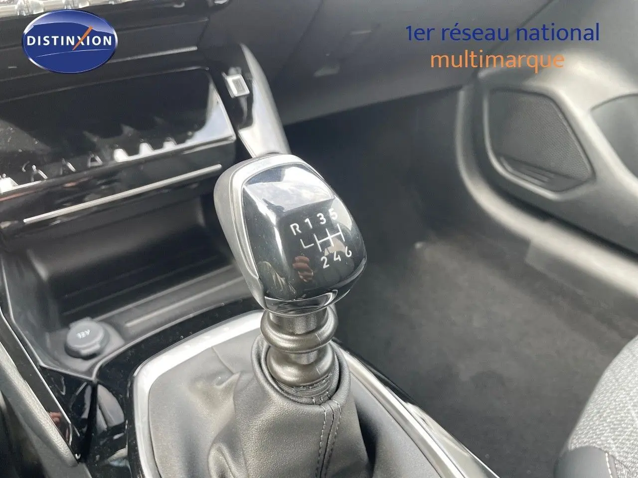 Le levier de vitesses manuel de la Peugeot 208 jaune Agueda Metal, vu en gros plan dans l'habitacle.