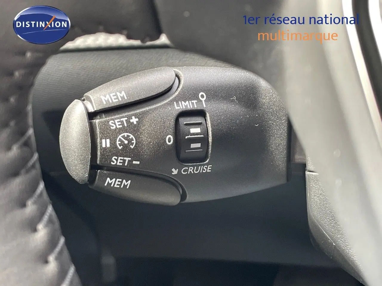 Gros plan sur la commande de régulateur de vitesse de la Peugeot 208 jaune Agueda Metal, côté gauche du volant.